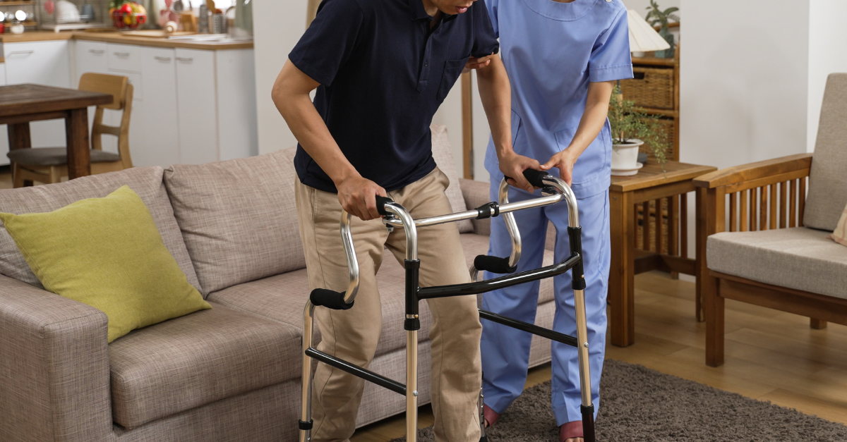 A man using a walking frame inside his home.
